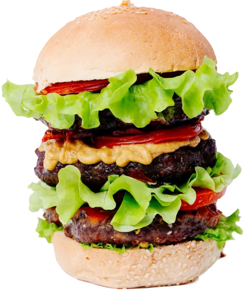 A tall double burger with layers of green lettuce and tomato between two patties
